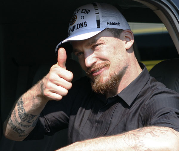 Boston Bruins defenseman Andrew Ference gives a thumbs-up to fans upon the team's return to Boston today.