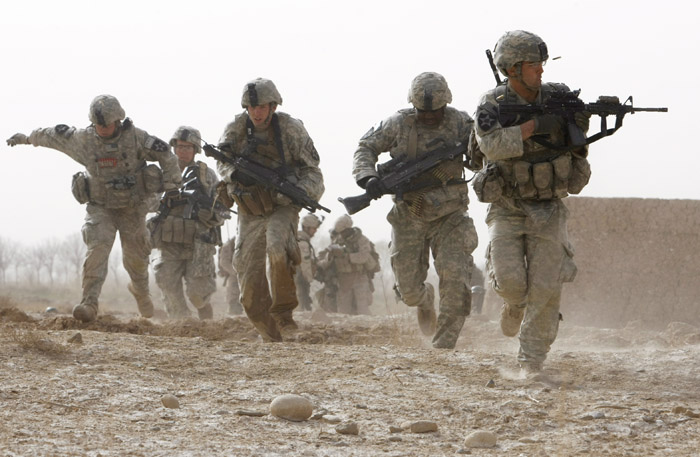 A U.S. soldier returns fire as others run for cover during a firefight with insurgents in Helmand province, southern Afghanistan, in this February 2010 photo.