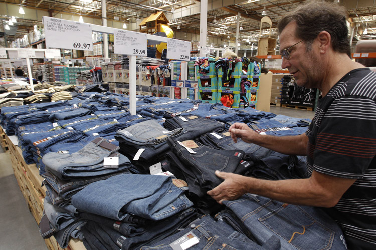 A shopper looks at Levi jeans at Costco in Mountain View, Calif., recently. Wholesale prices rose at the slowest pace in 10 months in May as food costs fell and gas prices rose by the smallest amount in eight months.