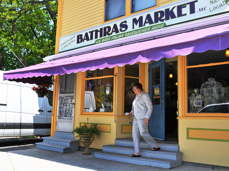 A patron exits Bathras Market in Willard Square in South Portland. The market has recently reopened.