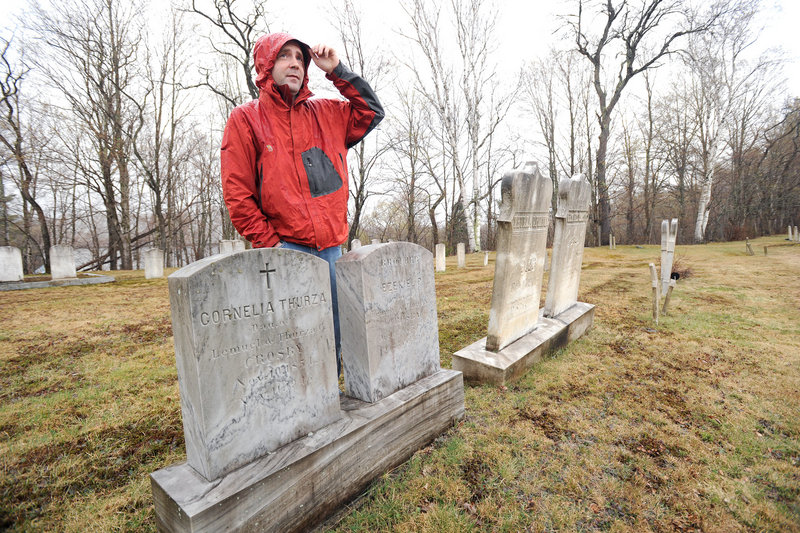 Ben Godsoe of the High Peaks Alliance land trust is leading an effort to build a 45-mile trail between Strong and Oquossoc that marks the places where Cornelia “Fly Rod” Crosby fished and worked. Here, he stands beside Crosby’s grave at the start of the trail in Strong.