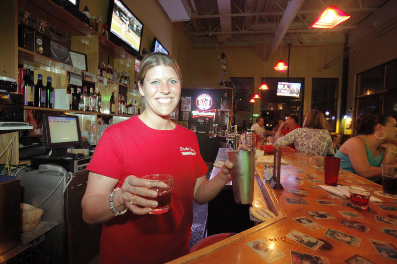 Allyson Carter, manager of The Strike Zone in Old Orchard Beach, pours a Washington Apple, which is made with Crown Royal, Apple Pucker and cranberry juice. The sports bar is on the main street downtown.