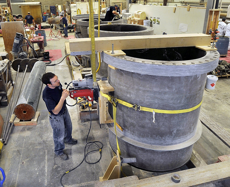 Jeremy Ubert drills a hole to add a flanged nozzle to a 54-inch-diameter fiberglass pipe at Kenway Corp. in Augusta.