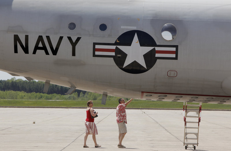 Kathi Myntii and Kevin Pewitt of Raymond check out a P3 Orion during a disestablishment ceremony at the Brunswick Naval Air Station on Tuesday. Her father flew with the Navy. "It's a momentous occasion," she said. "There's a lot of history out here."