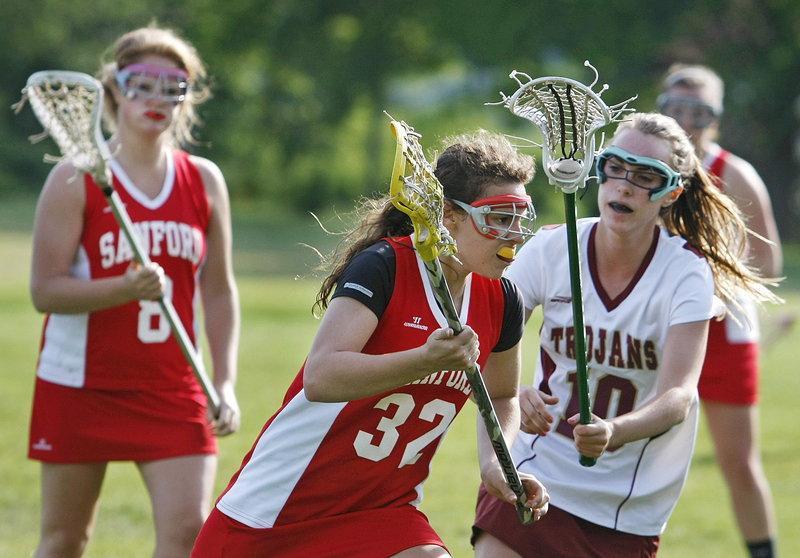 Autumn Wilkins of Sanford carries the ball while receiving defensive pressure from Michelle Giroux of Thornton Academy.