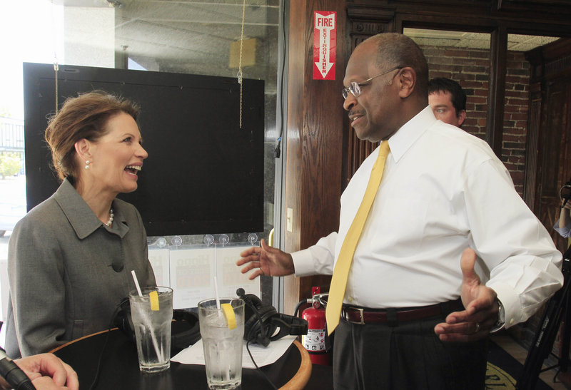 Rep. Michele Bachmann, R-Minn., runs across a fellow GOP presidential hopeful, businessman Herman Cain, at a radio show taping Tuesday in Concord, N.H. Bachmann also fielded media questions about another potential competitor, Sarah Palin.