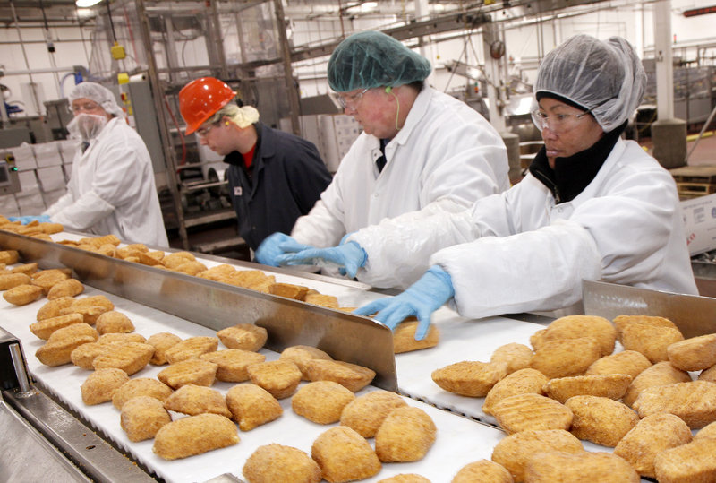 Barber Foods workers sort frozen chicken products Wednesday in the Portland plant, which will remain open. But production lines will be consolidated and the work force reduced.
