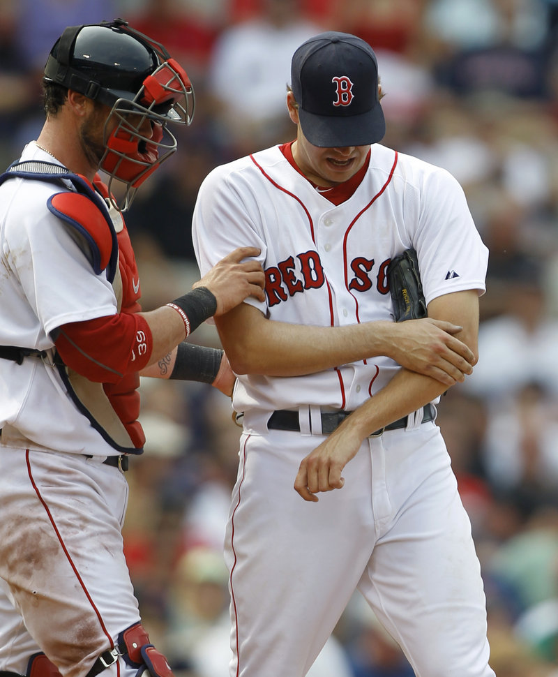 Rich Hill of the Red Sox is assisted by catcher Jarrod Saltalamacchia after injuring his forearm in the seventh inning.