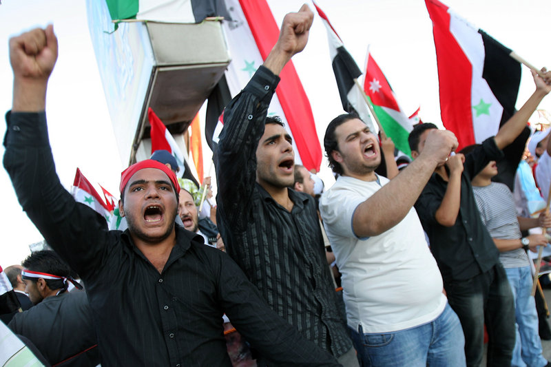 Protesters waving Syrian and Jordanian flags demand the resignation of Syrian President Bashar Assad, in Amman, Jordan, on Wednesday. Images of children killed in a government crackdown are circulating on YouTube, Al-Jazeera, Facebook and opposition websites.