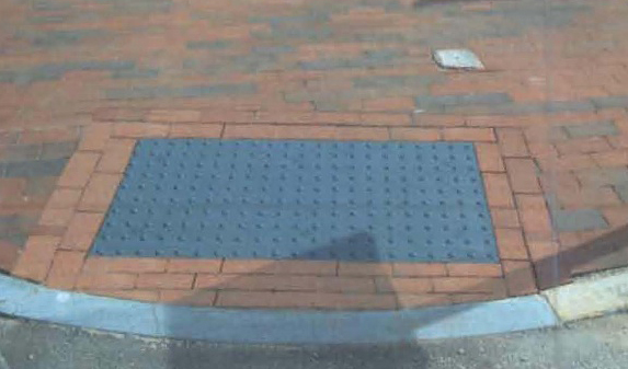 Curb cuts like the one at left textured gray tiles bordered by brick will be installed in Portland s historic districts as a cue to visually impaired people of areas where the sidewalk meets the street.