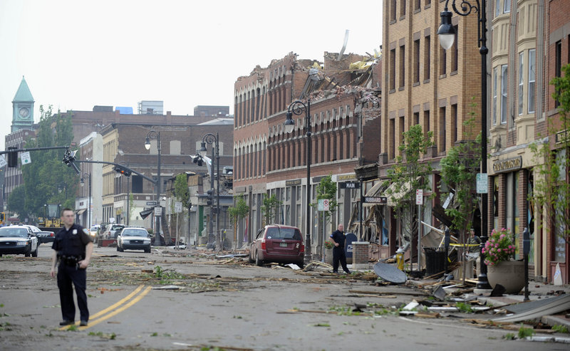 Debris litters Main Street in Springfield, Mass., on Wednesday, after the top floor of a building on the street was shorn off by a tornado. One office worker reported a “massive cloud of debris floating around in a circular, cylindrical fashion.”