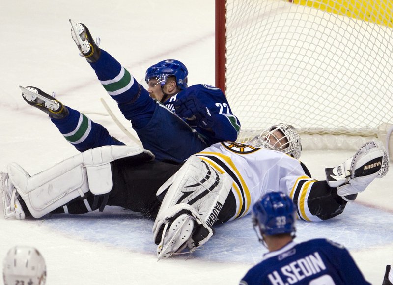 Boston goalie Tim Thomas lies sprawled on the ice with Vancouver’s Daniel Sedin on top during the Canucks’ 1-0 win in Game 1 of the Stanley Cup on Wednesday.