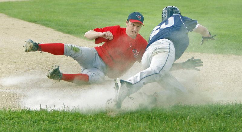 Devin Merritt of York dives back to third base Thursday after sliding past it, as Ryan Cavallaro of Gray-New Gloucester reaches for the ball. Merritt was safe because the ball got away. Gray-New Gloucester came away with a 7-4 victory at home.