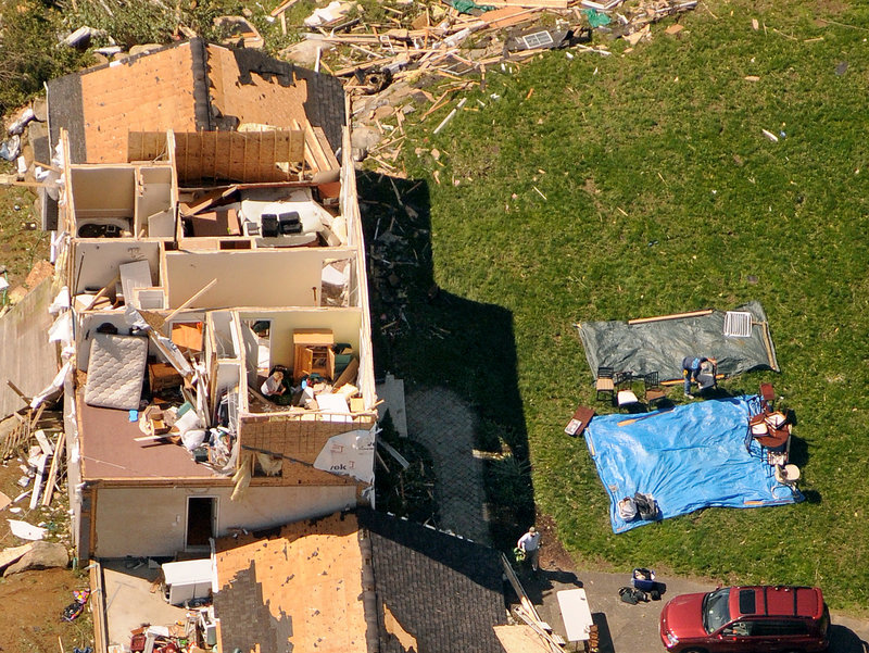 Homeowners in Brimfield, Mass. collect their belongings on tarps outside their house on Thursday. Residents in 19 Massachusetts communities were affected by late-afternoon tornadoes Wednesday, storms that shocked officials with their suddenness and violence.