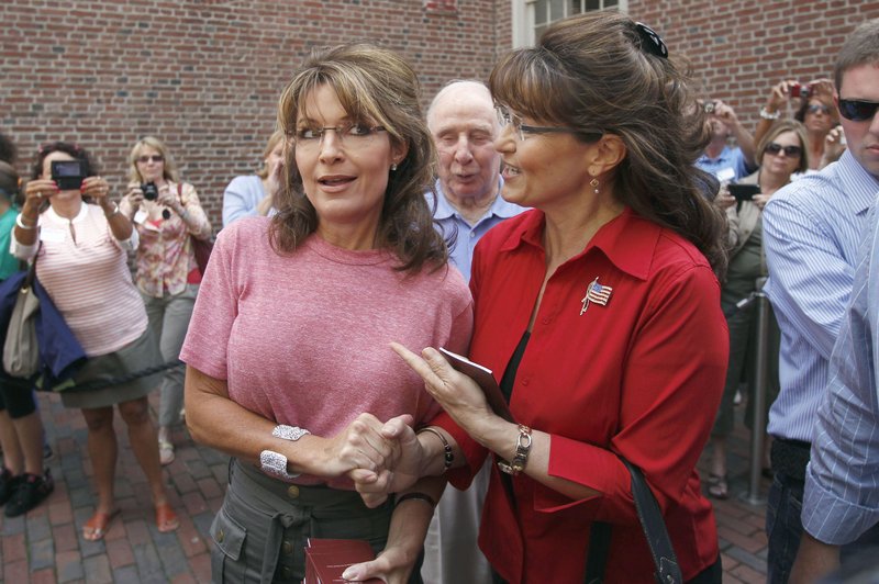 Former Alaska Gov. Sarah Palin, left, poses with celebrity impersonator Cecilia Thompson during a tour of Boston’s North End neighborhood on Thursday.