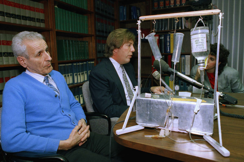 Dr. Jack Kevorkian, left, listens as his attorney, Geoffrey N. Fieger, talks with reporters with his suicide machine in the foreground of this 1991 photo. The assisted suicide advocate died Friday at the age of 83 at William Beaumont Hospital in Royal Oak, Mich., where he had been hospitalized since last month with pneumonia and kidney problems.