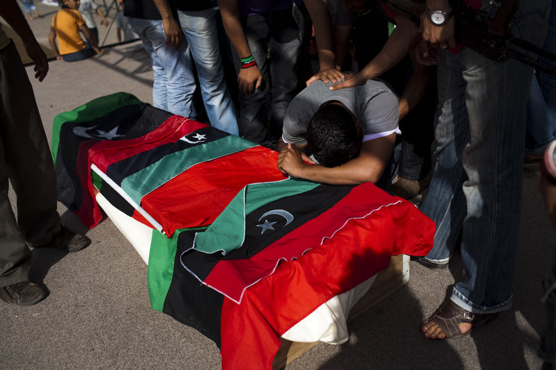 A man mourns on the coffin of a rebel fighter killed in the front line against Moammar Gadhafi's forces, during a burial in the rebel stronghold of Benghazi, Libya, on Saturday.
