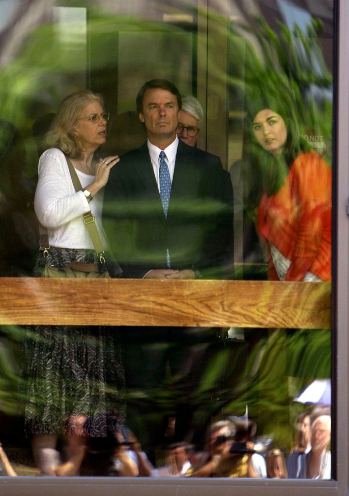 Former presidential candidate John Edwards and his daughter Cate, right, peer out of the federal building following a court appearance in Winston-Salem, N.C., on Friday. The woman at left is unidentified.