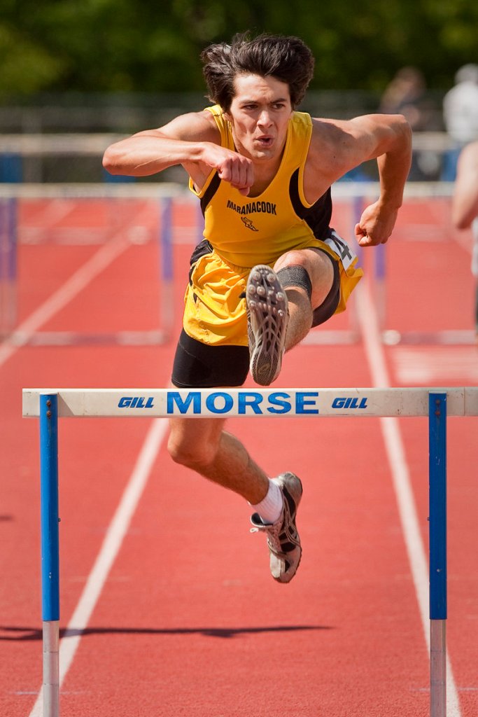 Tyler Watson of Maranacook has his eyes down the track as he clears the final barrier on his way to a victory in the Class C 300-meter hurdles