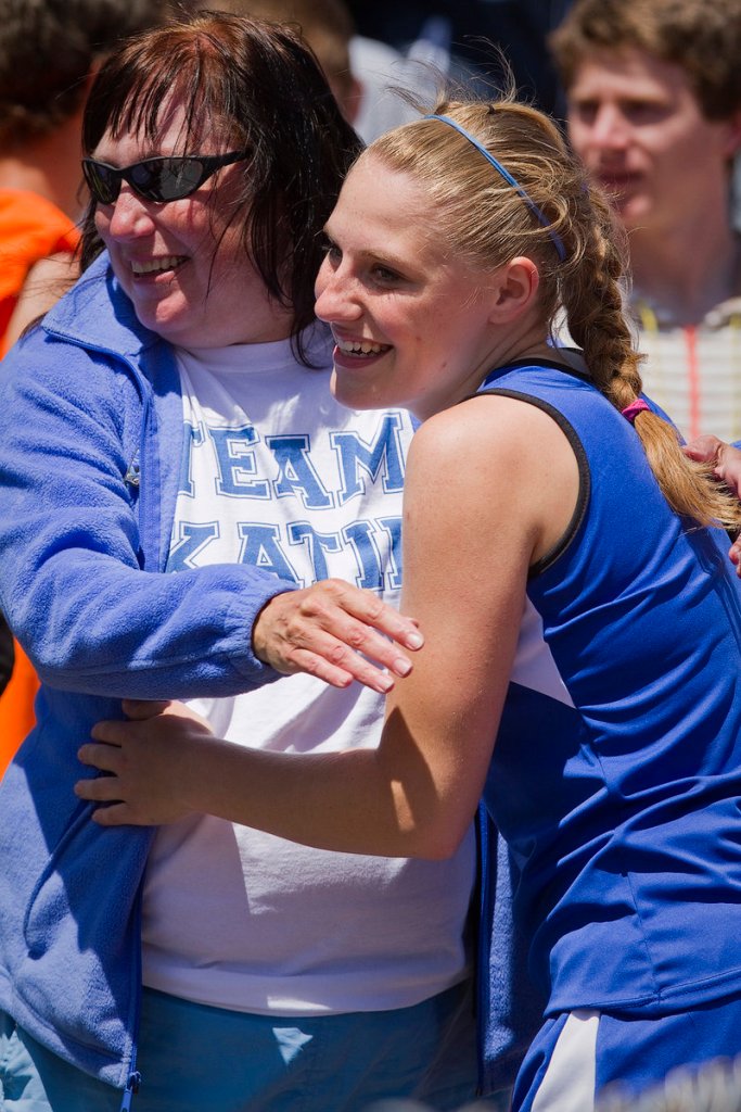 Katie Hatch of Old Orchard Beach gets a hug from her mom, Kim, after winning the 100-meter dash by .01 seconds in the Class C meet.