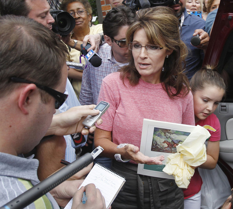 Former Alaska Gov. Sarah Palin, holding a booklet depicting Paul Revere, visits Boston’s North End during her “One Nation” bus tour last Thursday. At right is her daughter Piper.