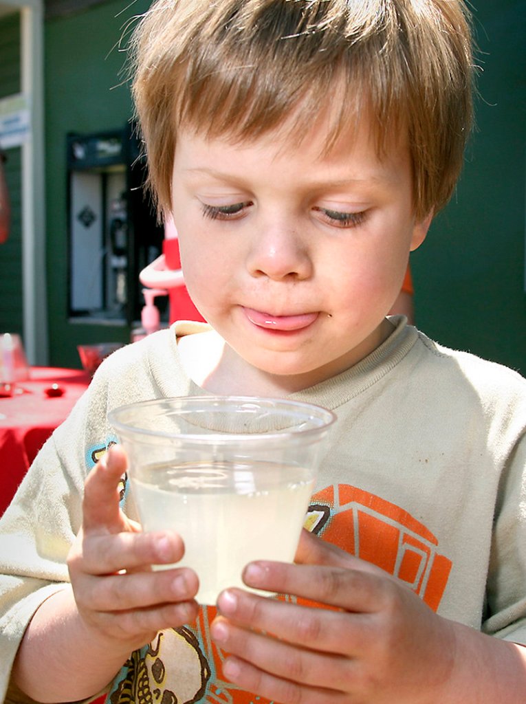 Dylan Doucette, 4, of Portland licks his lips as he drinks lemonade from an alien-themed lemonade stand created by Jai Morning and Carlos Braceras on North Street in Portland.