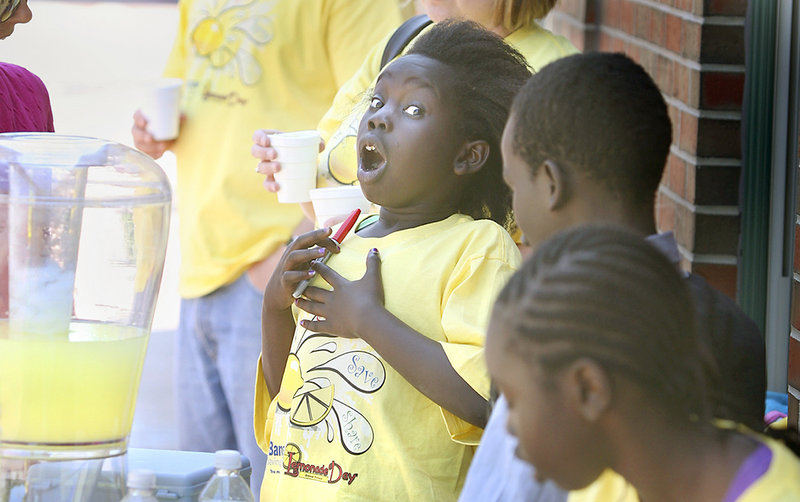 Akual Majok, 9, of Portland reacts to receiving a tip for good service at the Root Cellar's lemonade stand on Washington Avenue in Portland during Lemonade Day on Sunday.