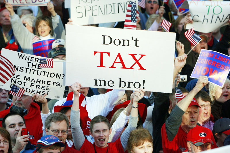 A woman holds a sign at a 2009 Atlanta Tea Party protest. Under strategist Grover Norquist’s anti-tax pledge, raising revenue in any way requires an equal tax cut elsewhere to avoid expanding the size of government.
