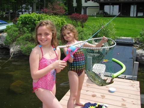 Aiyana, 10, and Dasey McNeill, 7, of Pittston show their first fish of the year, a 2 1⁄2 pound bass they caught at their grandmother Jackie McNeill’s house on Togus Pond on Memorial Day.