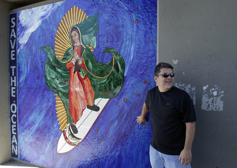 Nick Dinapoli of San Diego stands in front of an image of the Virgin of Guadalupe in Encinitas, Calif. Opinions vary, even among officials, on whether it must be removed.