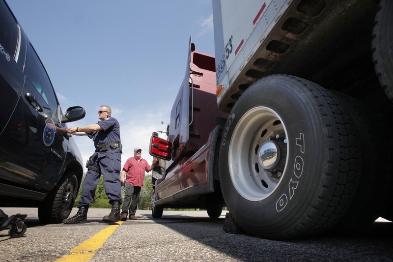 State Trooper Shane Northrup checks a truck driven by Tom Becker of Lagrange in York on Tuesday, the first day of a three-day annual truck enforcement effort. Becker was driving a load of groceries to Hannaford in South Portland.