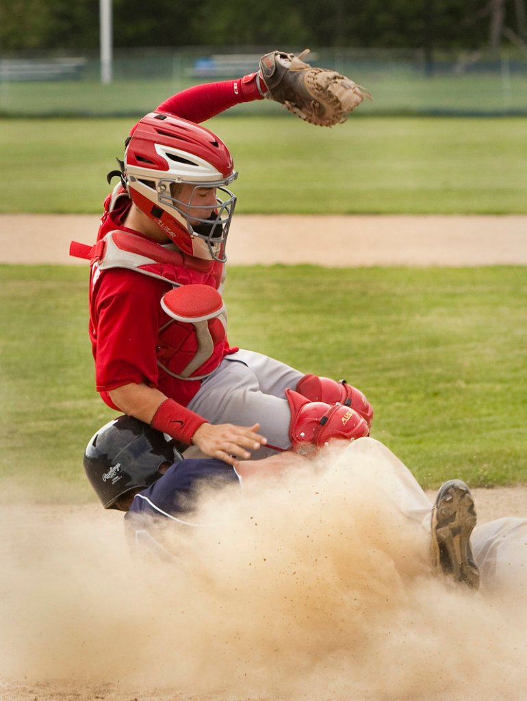 York’s Ryan Schoff slides home safely as Gray-New Gloucester catcher Tim Lerette tumbles in. The play tied the score at 1 in their Western Class B preliminary-round baseball game Tuesday in Gray.