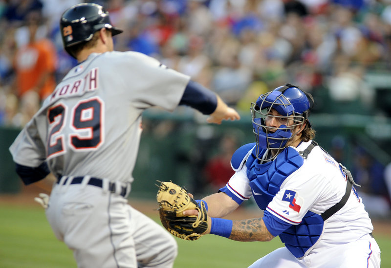 Texas’ Mike Napoli waits to put a tag on Detroit’s Danny Worth on Tuesday in Arlington, Texas. The Rangers won, 8-1.