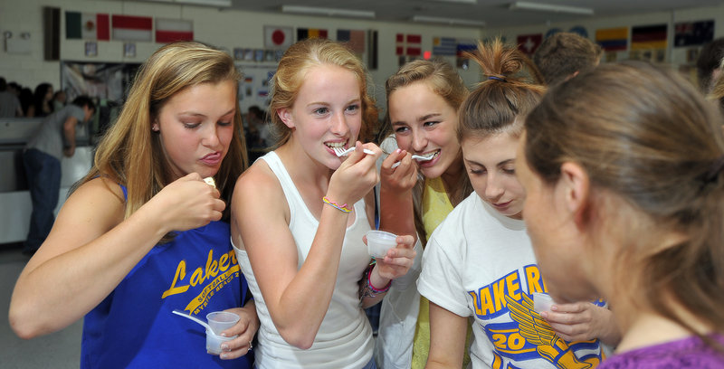 From left, students Kristina Morton, Hannah Perkins, Kayleigh Lepage and Brittany Hayes sample fresh hake as part of a taste test Wednesday at Lake Region High School. Listening to their opinions is Courtney Kennedy, right, the school’s health coordinator.