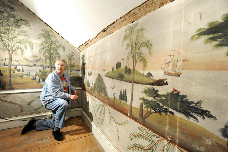 Jane Radcliffe, a board member of the Rufus Porter Museum, examines murals that are in the process of being moved from a home in East Baldwin to the new museum that is scheduled to open next year in Bridgton.