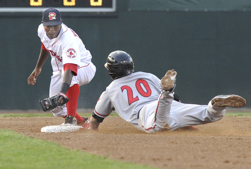 Portland's Oscar Tejeda slaps a tag on Richmond's Johnny Monell as he slides into an out that ended the top half of the second inning at Hadlock Field in Portland on Wednesday.