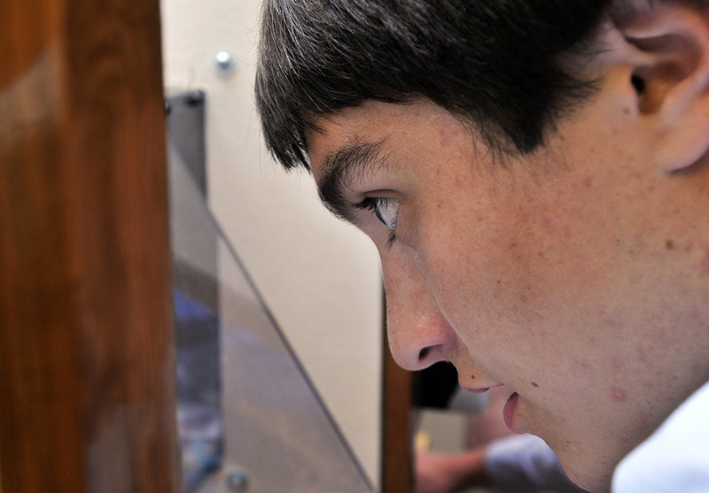 Evan LaMarre, a senior, peers into the test chamber of the wind tunnel created by eight Freeport students.