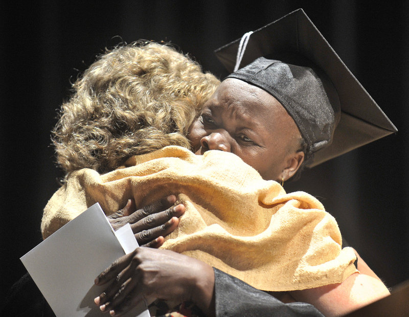 Portland Adult Education staff member Valerie deVuyst shares a hug with graduate Lia Boulis Kodi after presenting her an achievement award at Thursday night's graduation ceremony held at Portland's Merrill Auditorium. Graduates ranged in age from 18 to 68.
