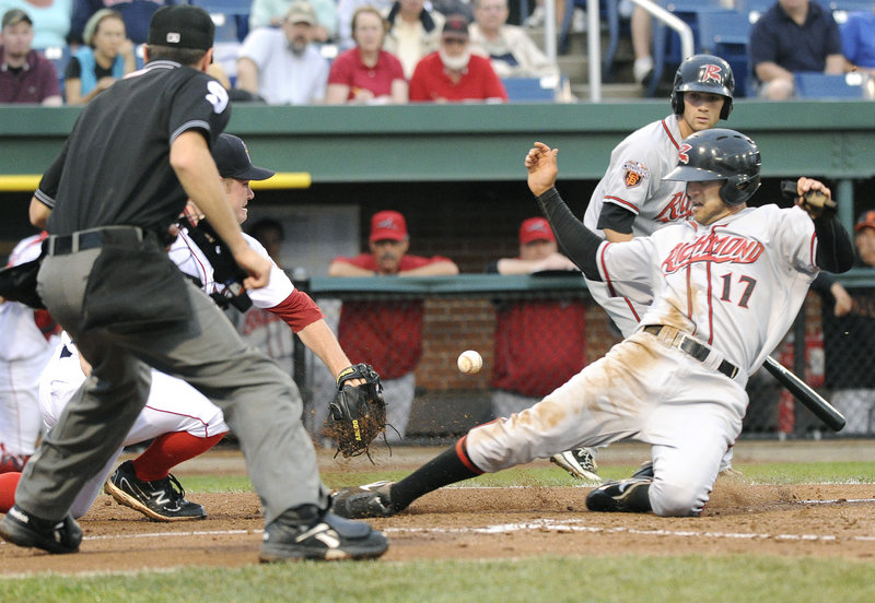 Justin Christian of the Flying Squirrels slides safely into home as Sea Dogs pitcher Alex Wilson awaits a late throw from catcher Ryan Lavarnway in Richmond’s 7-2 victory.
