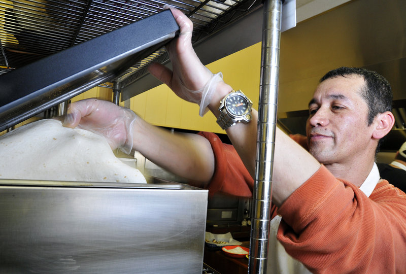 Manny Pena begins preparing an order at Taco Trio in South Portland.
