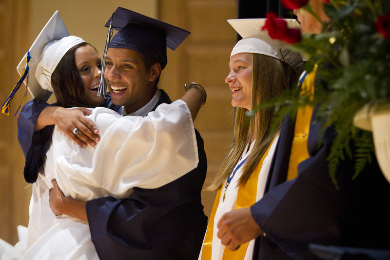Westbrook Class President Joshua Hand hugs classmate McKenzie Johnson during the school's commencement ceremony at Merrill Auditorium in Portland on Friday. To their right is Class Marshal Vanessa Bradbury.