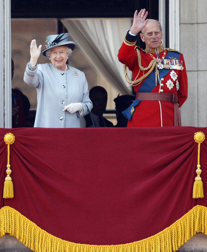 Queen Elizabeth II and Prince Philip wave from Buckingham Palace after returning from her official birthday ceremony in London on Saturday.