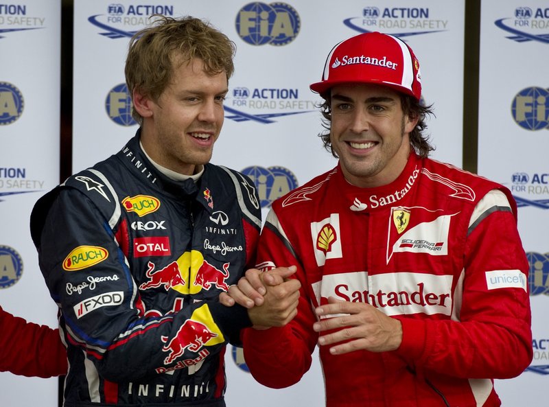 Sebastian Vettel, left, of Germany, is congratulated by the second-place qualifier, Ferrari’s Fernando Alonso of Spain, after taking the pole position for today’s Canadian Grand Prix in Montreal.