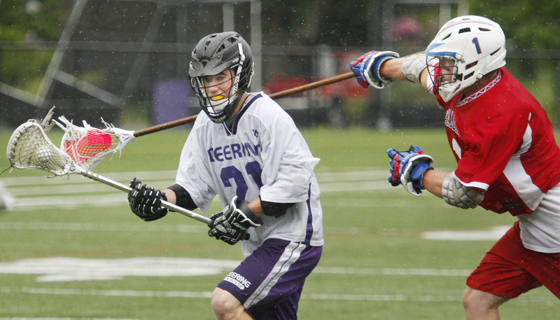 Matt Flaherty of Deering controls the ball and avoids a check by John Hall of Messalonskee during their Eastern Class A semifinal. Deering won, 8-6.