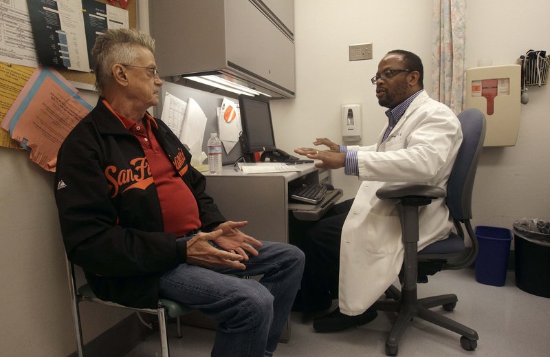 Randy Blach, left, talks to Dr. Malcolm John at the University of California, San Francisco's HIV clinic.
