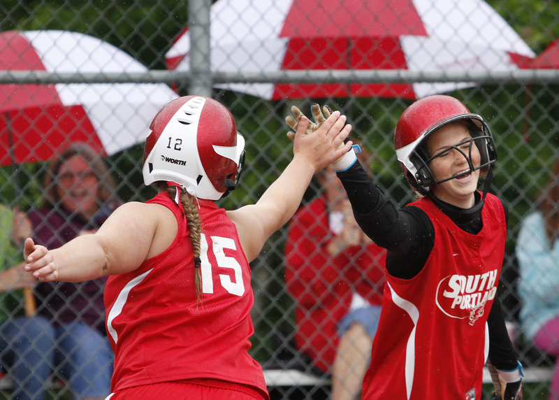 South Portland's Olivia Indorf, left, and Danica Gleason celebrate Saturday after scoring on Amanda Linscott's first-inning double in a 14-2 victory against McAuley.