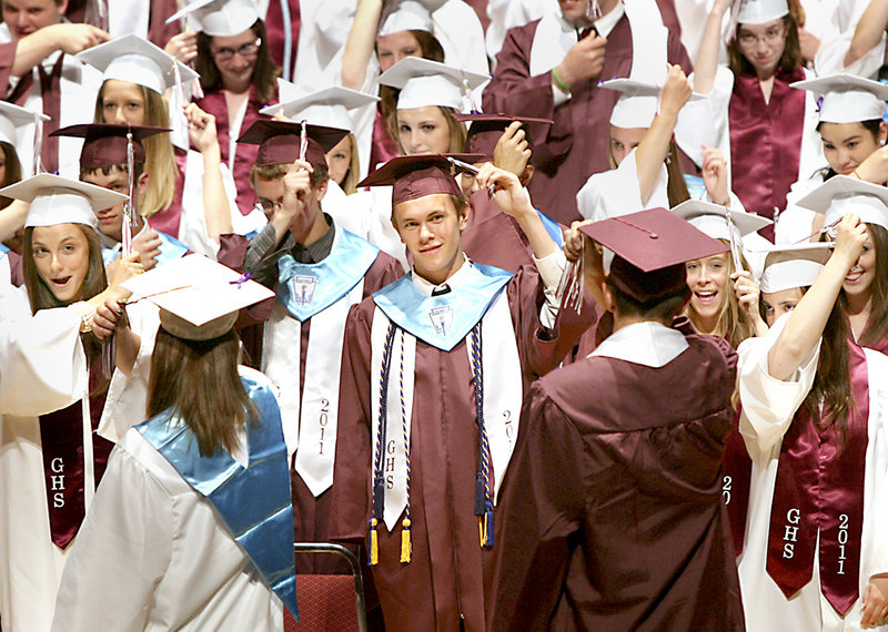 Andrew Ernest, center, turns his tassel in the midst of his fellow Gorham High graduates Sunday.