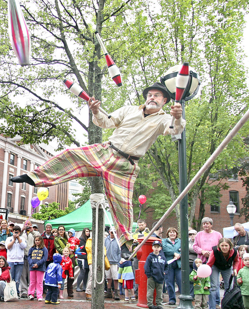 George Weatherbee of Portland balances on a slack rope while juggling in Tommy’s Park during Old Port Festival.