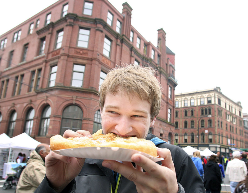 Casey Olesen of Portland eats fried dough Sunday at during the 38th annual Old Port Festival in Portland, which drew an estimated 25,000 people.