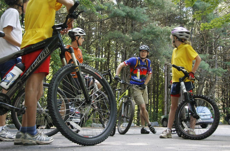 Beginning mountain bikers listen to a leader last summer at Bradbury Mountain State Park.